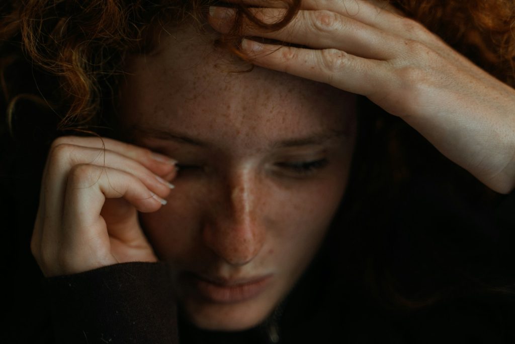 a close up of a person holding their head