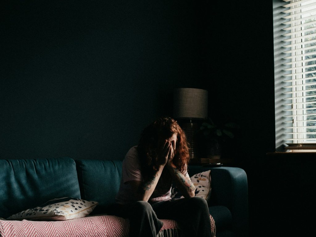 woman in black tank top sitting on black couch